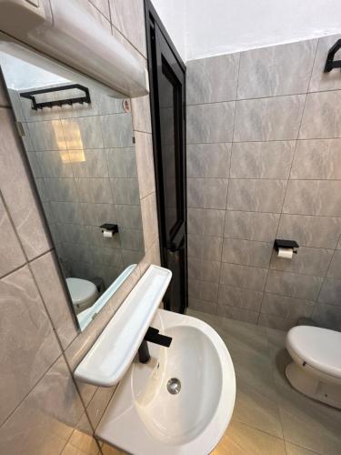 a bathroom with a sink and a mirror at Central Residence & Conciergerie Ouaga 2000 in Ouagadougou