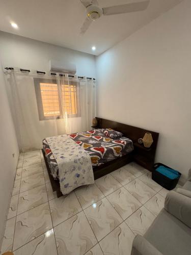 a bedroom with a bed and a couch at Central Residence & Conciergerie Ouaga 2000 in Ouagadougou