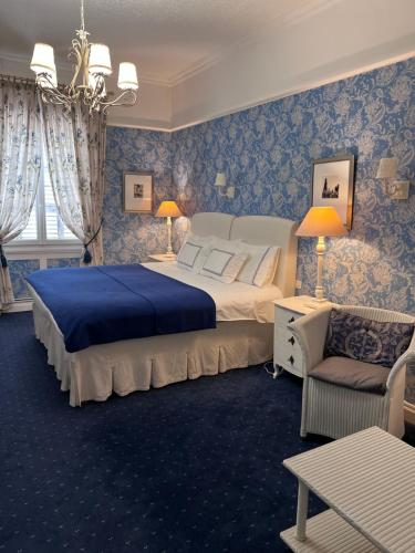 a bedroom with a large bed with blue wallpaper at Château de Villars in Villars
