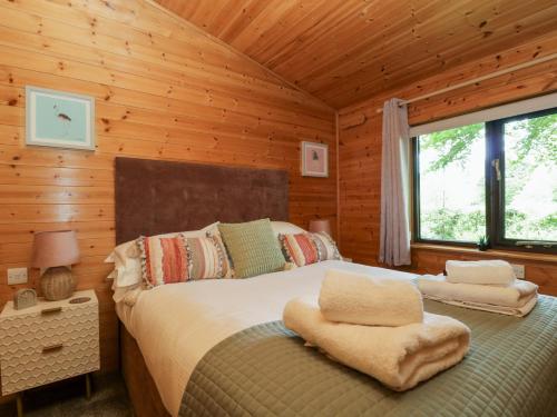 a bedroom with a bed in a log cabin at Derwent Lodge in Keswick