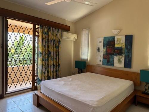 a bedroom with a large bed and a window at Dodo Casita House in Tamarin