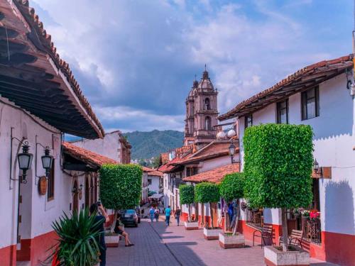 a street in a town with a clock tower in the background at Posada Real del Valle in Valle de Bravo