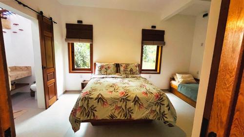a bedroom with a bed and two windows at Casa Miava - Studio 1 - Cozy place a few meters from the beach in Marau