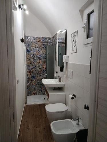 a bathroom with a sink and a toilet and a mirror at CASA NiNì in Trani
