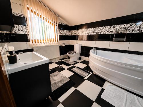 a black and white bathroom with a tub and a sink at Casa TOP Cristina in Poiana Teiului