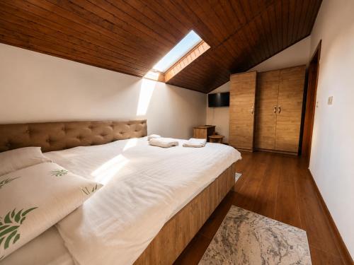 a bedroom with a large bed with white sheets at Casa TOP Cristina in Poiana Teiului