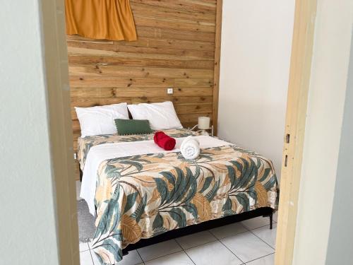 a bedroom with a bed with a wooden headboard at Bas de villa 3 chambres - Jardin privé - 20 minutes aéroport in Baie-Mahault
