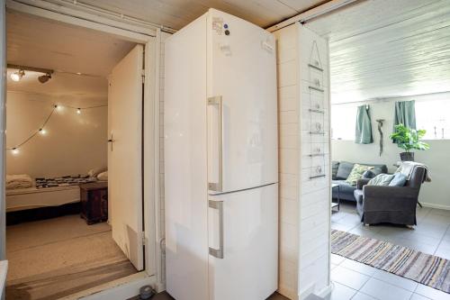 a kitchen and living room with a refrigerator in a room at Cozy summer apartment in Archipelago in Öckerö