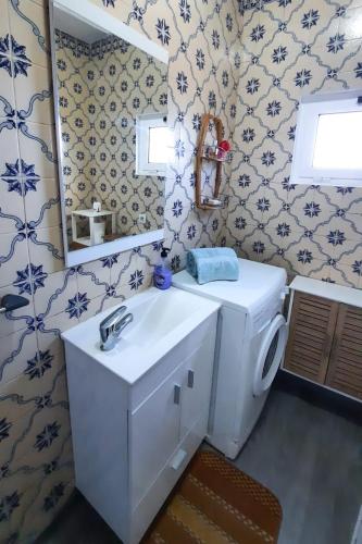 a bathroom with a sink and a toilet and a mirror at Quinta do Norte - Biscoitos in Biscoitos