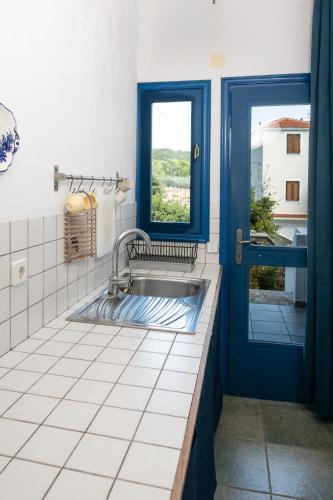 a bathroom with a sink and a window at Ikion Studios in Steni Vala Alonissos