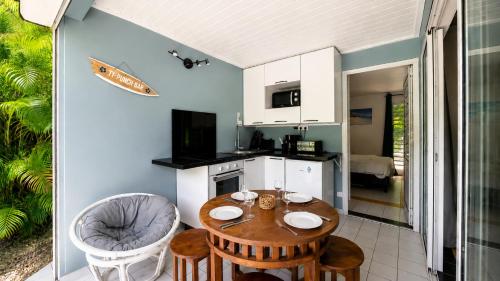 a kitchen and dining room with a table and chairs at L'Ecrin d'Oliv - Jardin, Accès plage, Calme assuré in Grand-Bourg