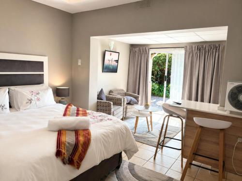 a bedroom with a bed and a desk in it at Comfort e Casa Lodge Near OR Tambo Airport in Kempton Park