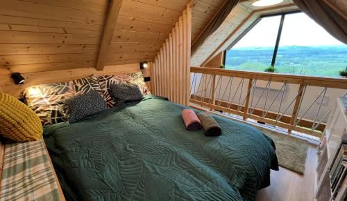 a bed in a room with a large window at Pajkos Présház in Bakonycsernye
