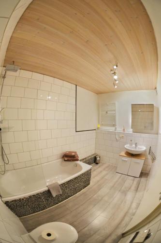 a large bathroom with a tub and a sink at Appartement Archimedes - Modernes Wohnen in historischer Drostei im Südharz in Walkenried