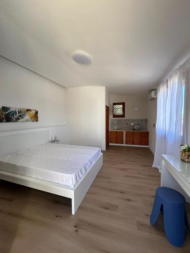 a bedroom with a white bed and a blue stool at Villa Silvia in Erice