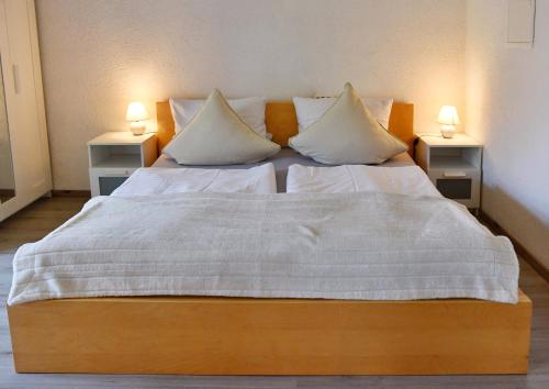 a bedroom with a large bed with two night stands at Appartement Archimedes - Modernes Wohnen in historischer Drostei im Südharz in Walkenried