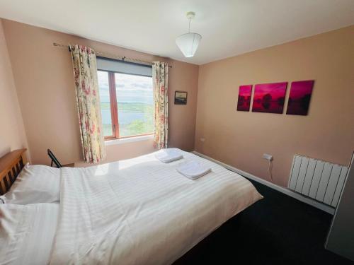 a bedroom with a large bed and a window at The Westings in Tingwall