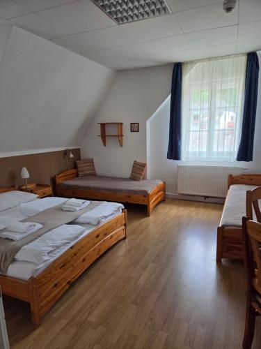 a room with two beds and two chairs in it at Hotel Alpin Murau in Murau