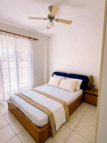 a bedroom with a bed with a ceiling fan at Elizabeth's Home in Flogita