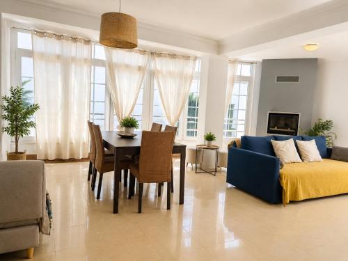 a living room with a blue couch and a table at Aomo-casa parede in Parede