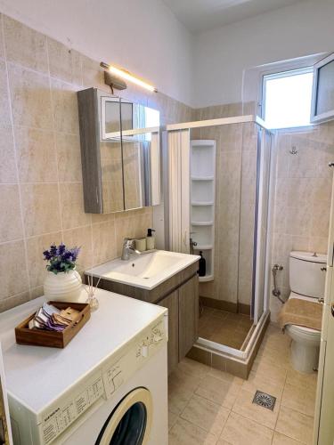 a bathroom with a sink and a washing machine at Elizabeth's Home in Flogita