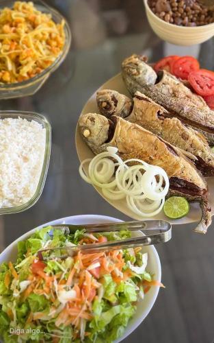 a table with plates of food with rice and vegetables at Villa Verde Chalés e Restô in Patos