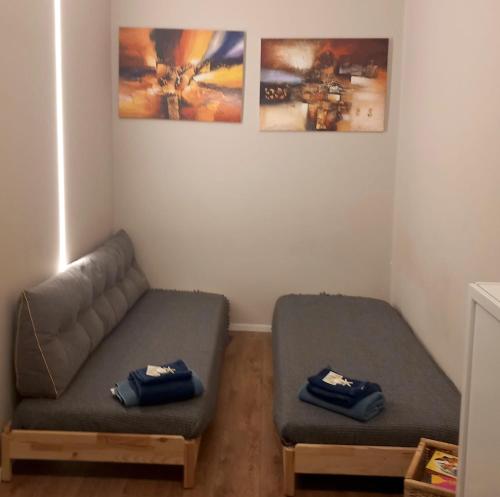 a living room with a couch and some pictures on the wall at LePetit in Porto Santo Stefano