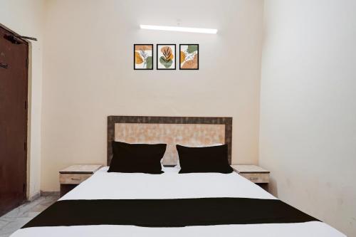 a bedroom with a white bed with black pillows at Hotel O Sector 12 Ghaziabad Formerly VIP Inn in Ghaziabad