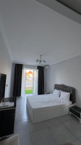 a bedroom with a white bed and a large window at Astara Villa Boutique Hotel in Astara