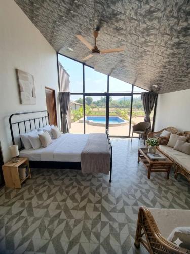 a bedroom with a bed and a living room with a couch at CP Villa Resort in Bhāweghar