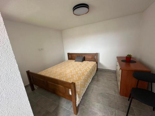 a bedroom with a bed and a desk with a laptop on it at Vikendica za odmor in Kloštar Ivanić