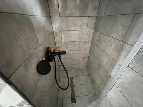 a shower with a black shower head in a bathroom at Vikendica za odmor in Kloštar Ivanić