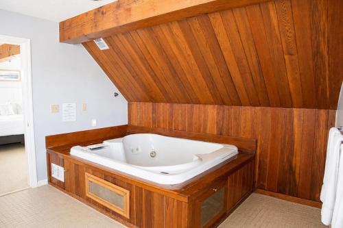 a bath tub in a bathroom with wooden walls at Elmwood Resort Hotel in Wells