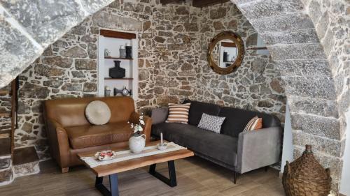 a living room with a couch and a table at MENELAUS Stone House in Fourní