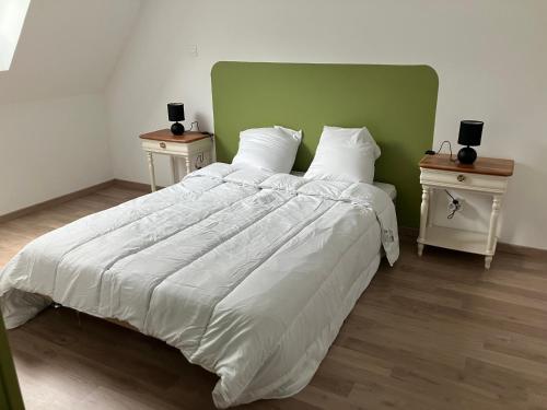 a bedroom with a large bed with two night stands at Maison campagne in Champ-du-Boult