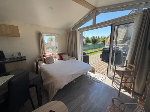 a bedroom with a bed and a large sliding glass door at Chalet Bois in Torcy-le-Petit