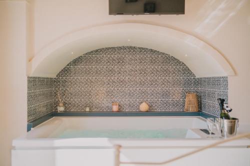 a bath tub in a bathroom with a tile wall at La Dimora del Vicolo - Apartment in Francavilla Fontana