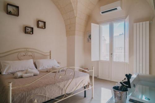 a bedroom with a bed and a large window at La Dimora del Vicolo - Apartment in Francavilla Fontana