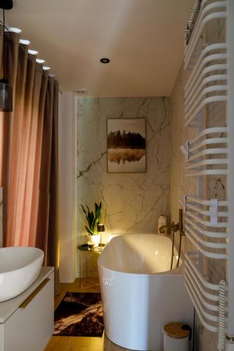 a bathroom with a large tub and a sink at Szyszkowa Stodoła in Milejczyce