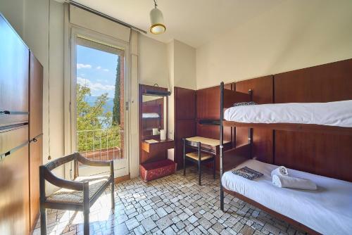 a room with two bunk beds and a desk and a window at Villa Lucy - Lake view in Varenna