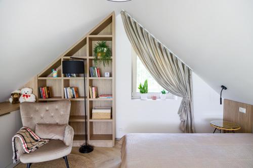 a bedroom with a bed and a chair and a book shelf at Szyszkowa Stodoła in Milejczyce