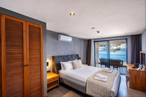 ein Schlafzimmer mit Bett und Meerblick in der Unterkunft İsolina Bodrum in Bodrum City