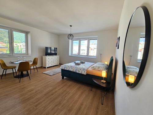 a bedroom with a bed and a mirror and a table at Apartmán KVETINKA v centre Žiliny s KAVIARŇOU in Žilina
