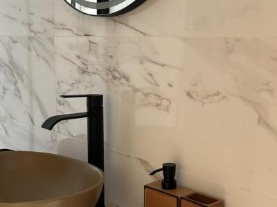 a bathroom with a tub and a marble wall at PiuPiuStays in Vermelho