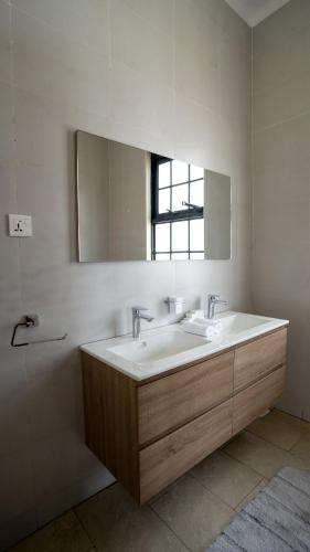 a bathroom with two sinks and a mirror at Bella Vista Villas Ltd in Mbarara