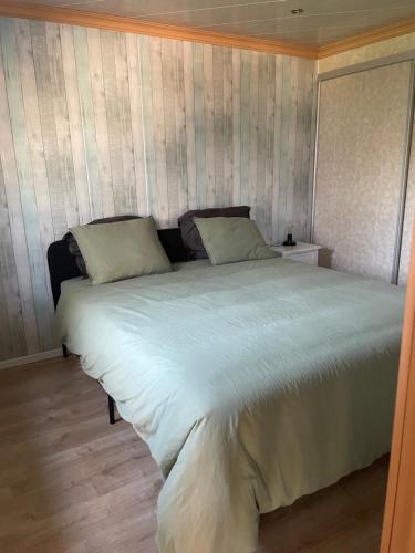 a bedroom with a large bed with white sheets at Het Kempens huisje in Lille