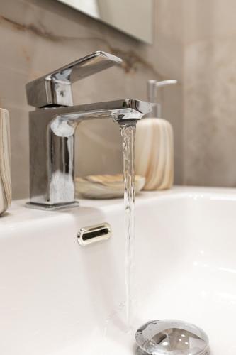 a bathroom sink with water running from a faucet at Elysian Studios in Mavrovouni