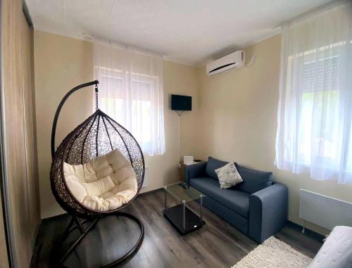 a living room with a swing chair and a couch at Purple Madame in Balatonszárszó