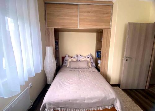 a small bedroom with a bed with a dresser at Purple Madame in Balatonszárszó