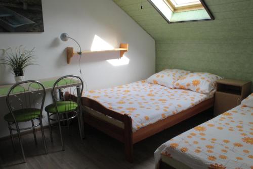 a bedroom with a bed and two chairs and a window at Dworek in Swarzewo